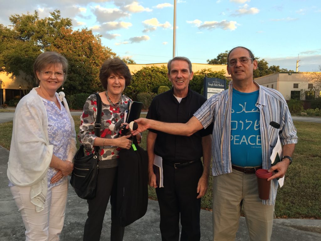 Catholic, Conservative Jewish, and Baha'i friends smile after a beautiful meeting. 